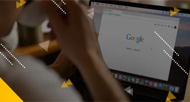 person drinking coffee looking at Google search screen on their laptop