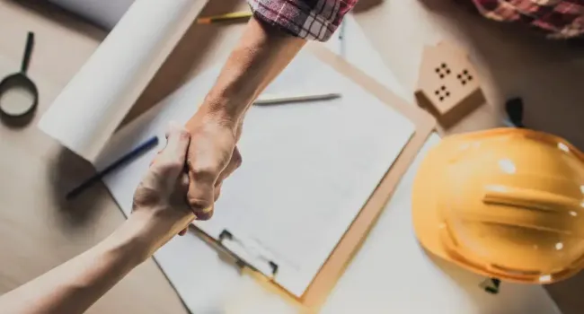 top-view-hand-shake-of-engineer-and-building-contractor-on-table