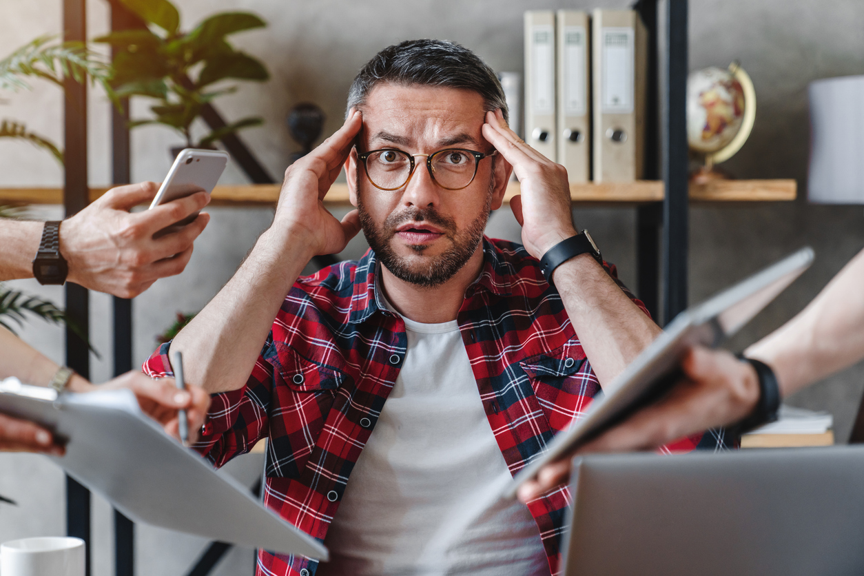 man holding his head from digital burnout